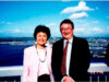 The Middlefield Farm Story 100+ Years of the Nakata Family on Bainbridge island Smiling older couple posing on a ship's railing with a harbor and blue sky in the background.